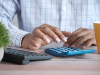 Person using a calculator for debt repayment and loan planning